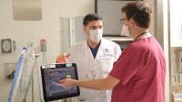 Two doctors review data on a computer screen
